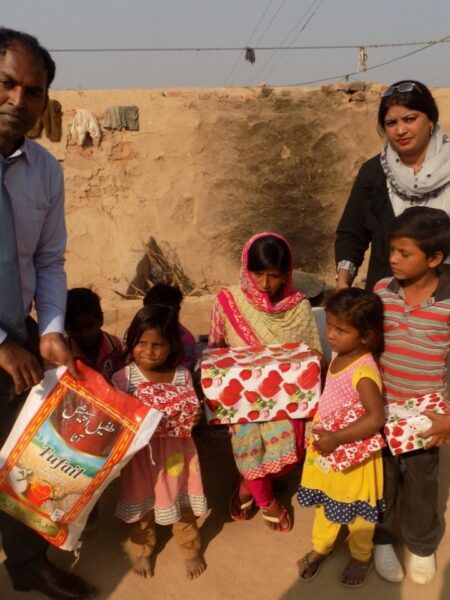 Pastor Rafaqat giving presents & rice to families - copy