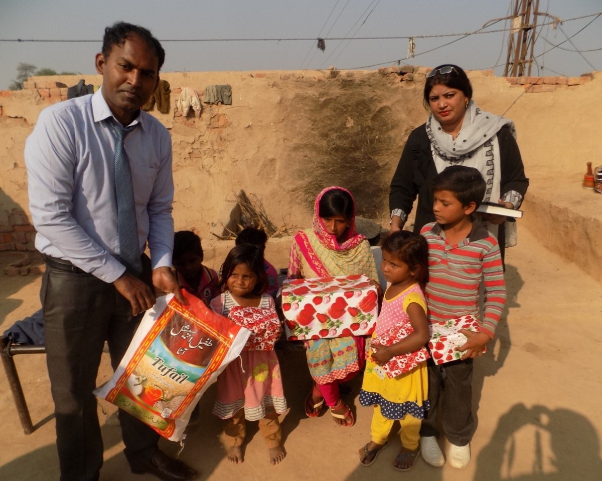 Pastor Rafaqat giving presents & rice to families - copy